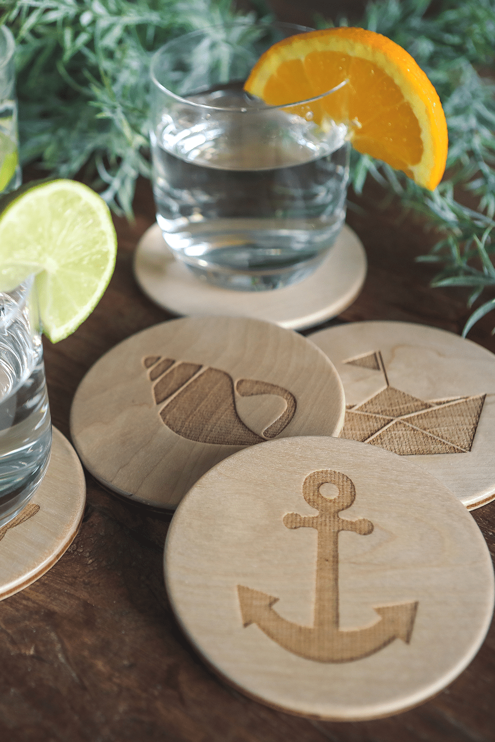 Unterschiedliche Untersetzer aus Holz mit maritimen Motiven, dekoriert auf einem Tisch.