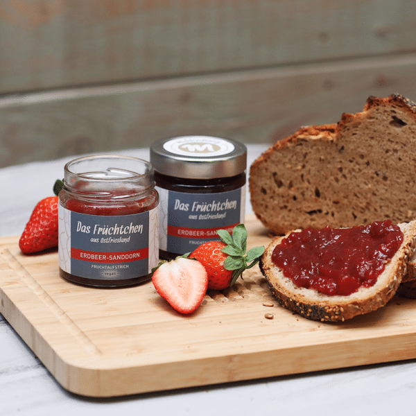 middenmang Fruchtaufstrich das Früchtchen in Erdbeer Sanddorn auf Holzbrett mit Brot und Erdbeeren