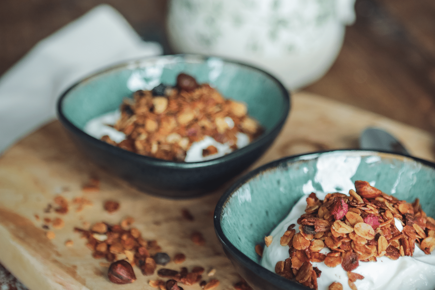 Zwei Sorten Knuspermüsli in Keramikschalen angerichtet.