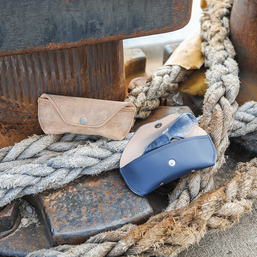 Zwei Brillenetuis auf einem Tau, eins geöffnet mit herausguckender Sonnenbrille, eins geschlossen.