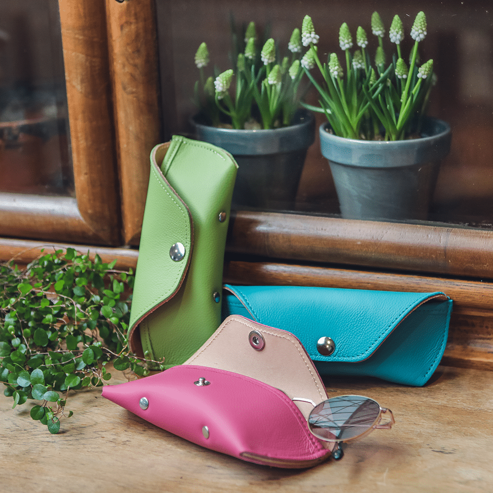 Drei bunte Brillenetuis in den Farben fleuro, türkis und apfel.