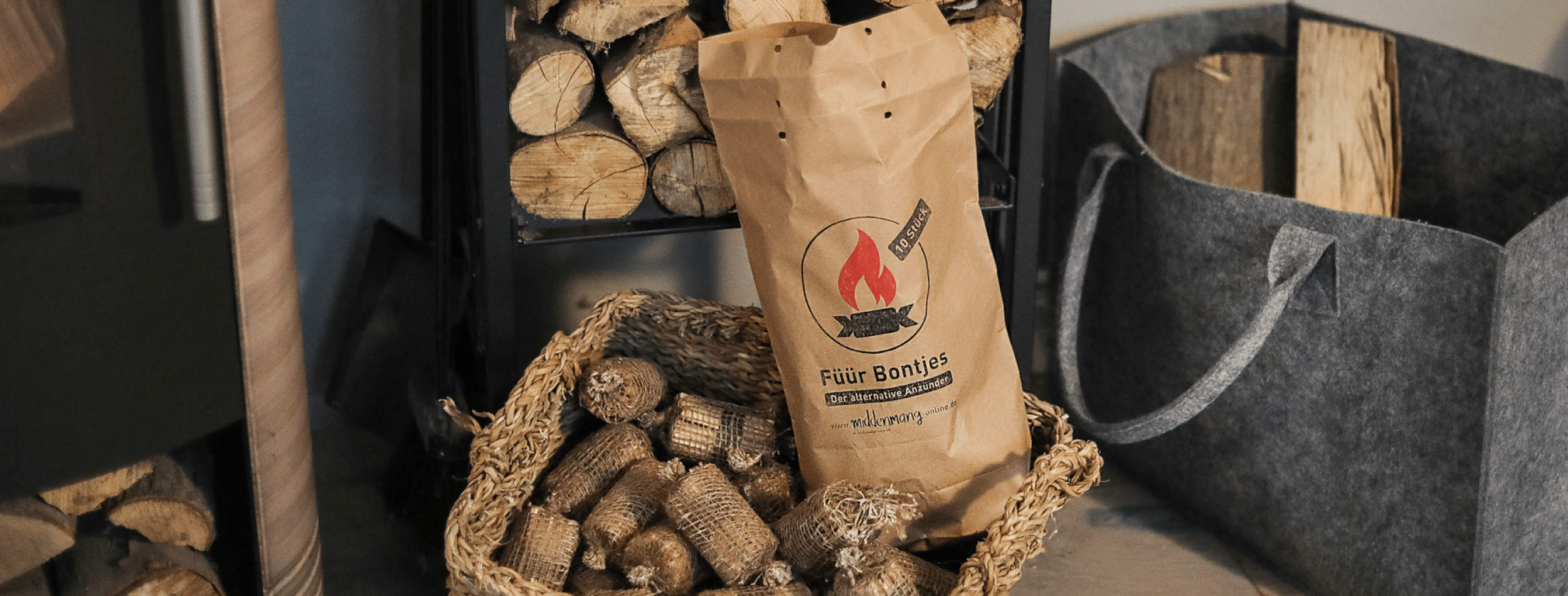 Knuspermüsli Apfel-Zimt steht im Garten auf Holzkiste neben Äpfeln und einer Schale Müsli.