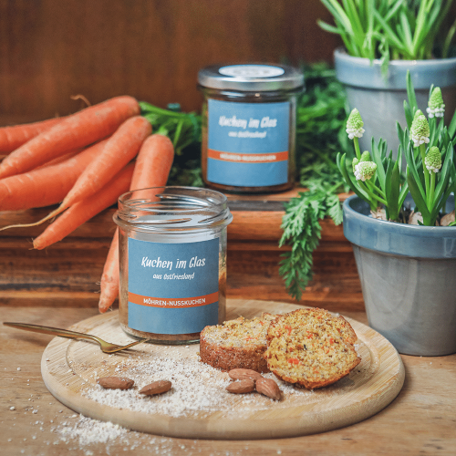 Möhren-Nusskuchen aus dem Glas, angerichtet auf einem Holzbrettchen.