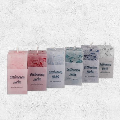 Diverse rustikale Kerzen in diversen Farben in eckig mit der Aufschrift Ostfreesen Lücht.