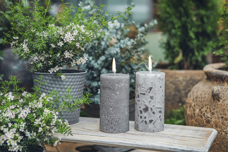 Drei Rundkerzen in Blautönen mit der Aufschrift Ostfreesen Lücht stehen auf Tisch mit Deko.