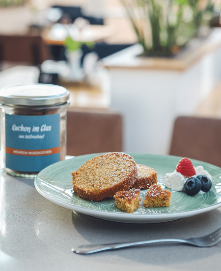 Schokoladenkuchen mit Schuss im Glas, von middenmang, in Scheiben geschnitten und auf einem Teller mit Kirschkompott, Sahne und Puderzucker angerichtet.