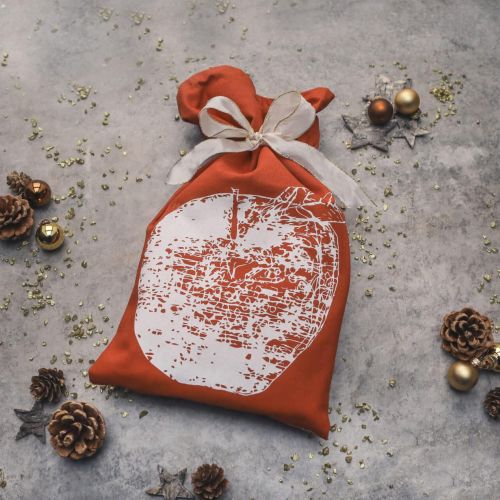 Eine Person reinigt ein Glas mit einem hellblauen Geschirrtuch mit dunkelblauem Fisch-Motiv.