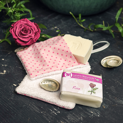 Lanolin-Naturseife mit Rosenduft und mit Seifensäckchen in rosa.