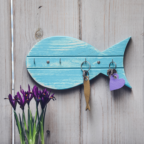 Blaues Schl&uuml;sselbrett aus Holz, in Form eines Fisches, mit vier Metallhaken und zwei Schl&uuml;sseln.