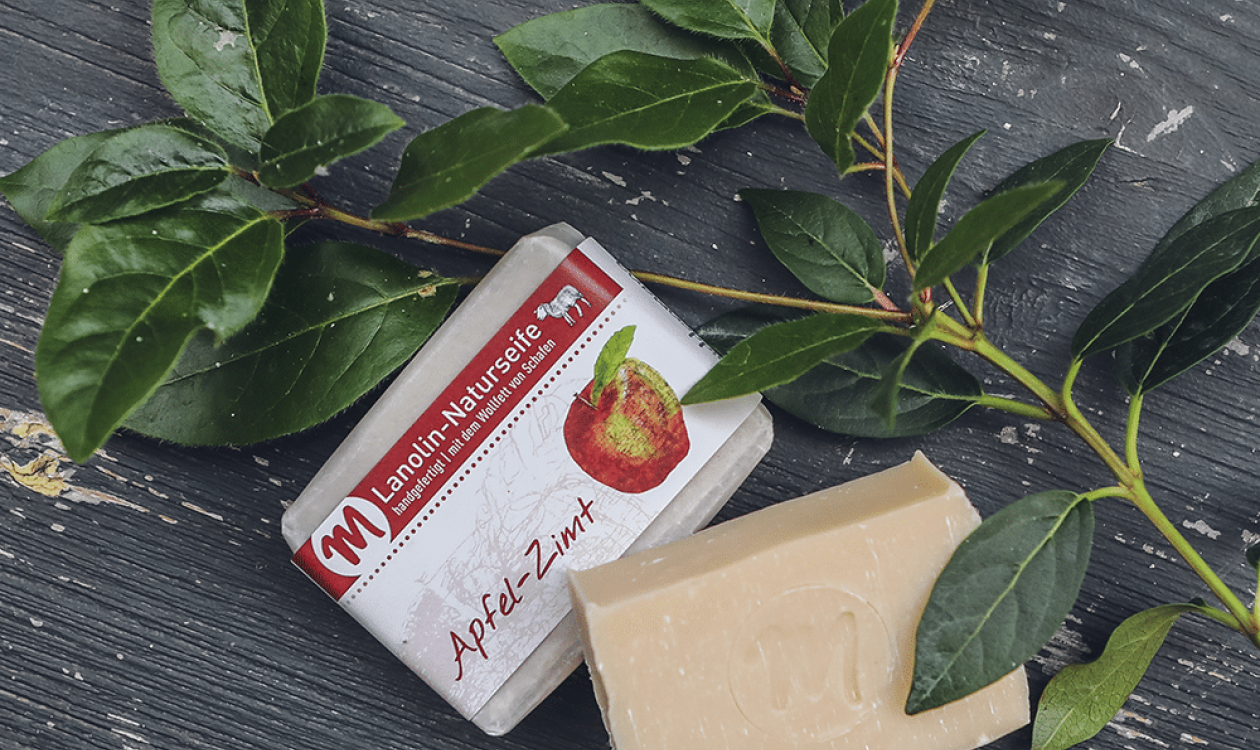 Lanolin-Naturseife mit Apfel-Zimt-Duft, mit grünem Zweig.