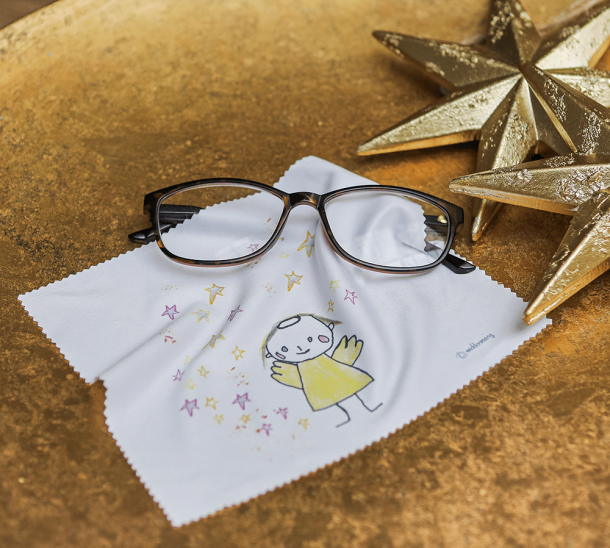 Brillenputztuch mit goldigem Engel mit Brille und goldenen Sternen im Hintergrund.
