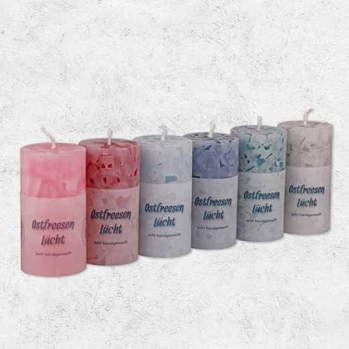 Diverse rustikale Kerzen in diversen Farben in rund mit der Aufschrift Ostfreesen Lücht.