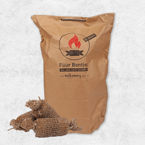 Handgemachte Anzünder liegen vor ihrer Verpackung aus Papier mit der Aufschrift Füür Bontjes.